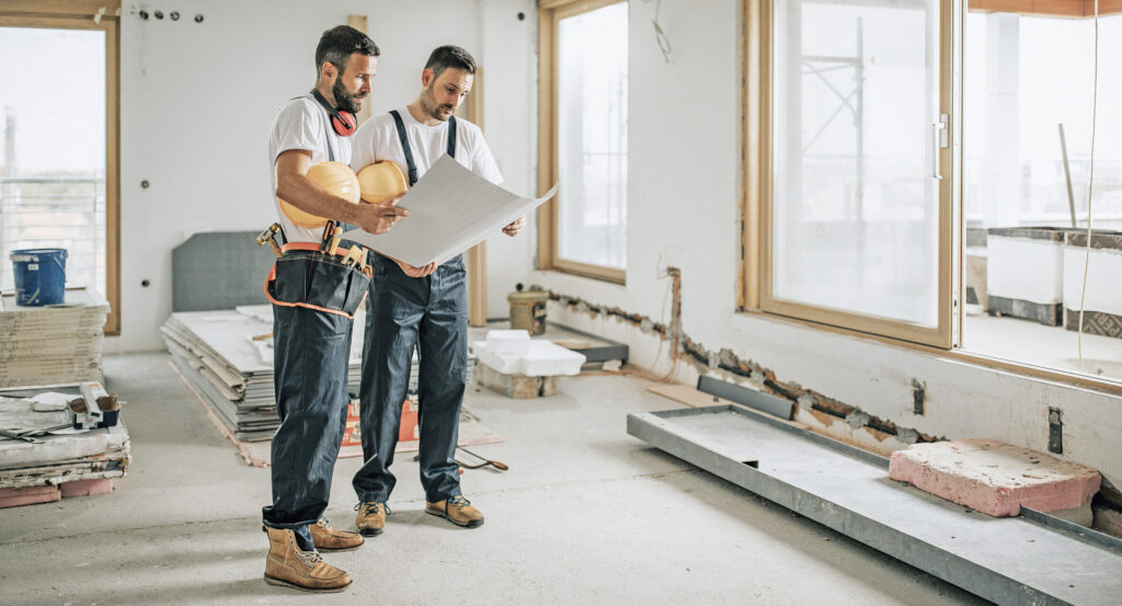 Bauarbeiter sehen sich einen Plan an